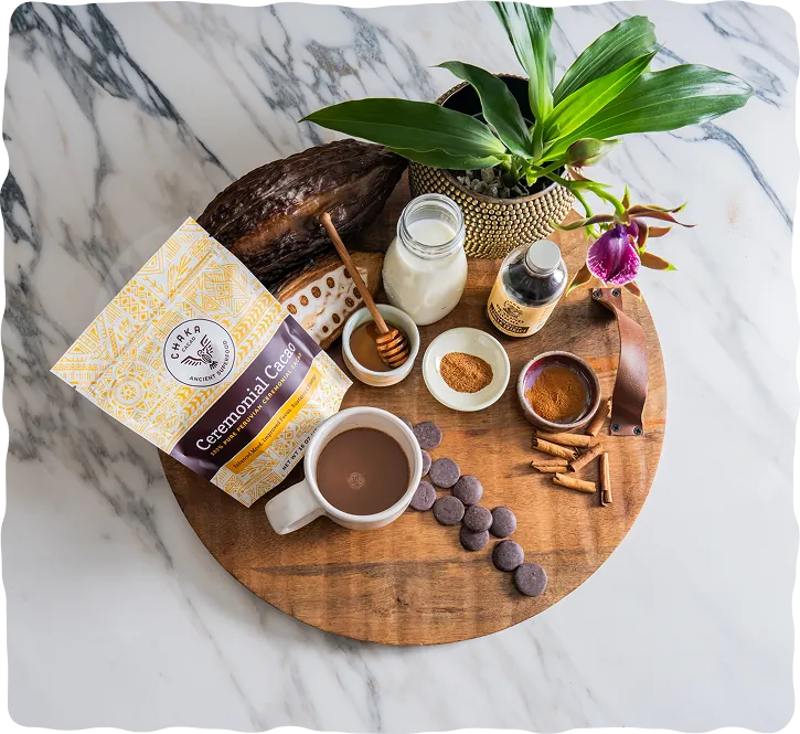 Bag of Chaka Peruvian ceremonial cacao with a cup of cacao, cacao discs, milk, honey and spices on a wooden board