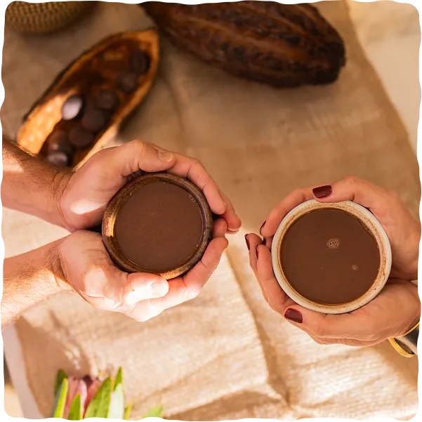 Two people holding cups of ceremonial cacao