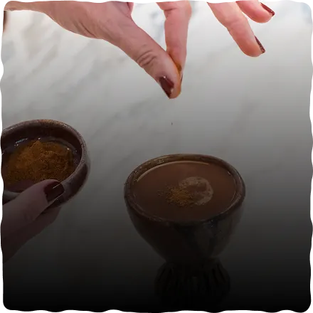 Adding a pinch of spice to a cup of ceremonial cacao