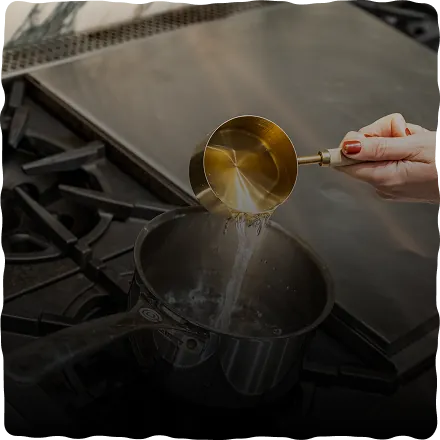 Pouring water into a saucepan to heat it