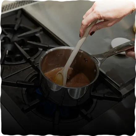 Stirring ceremonial cacao in a saucepan until smooth
